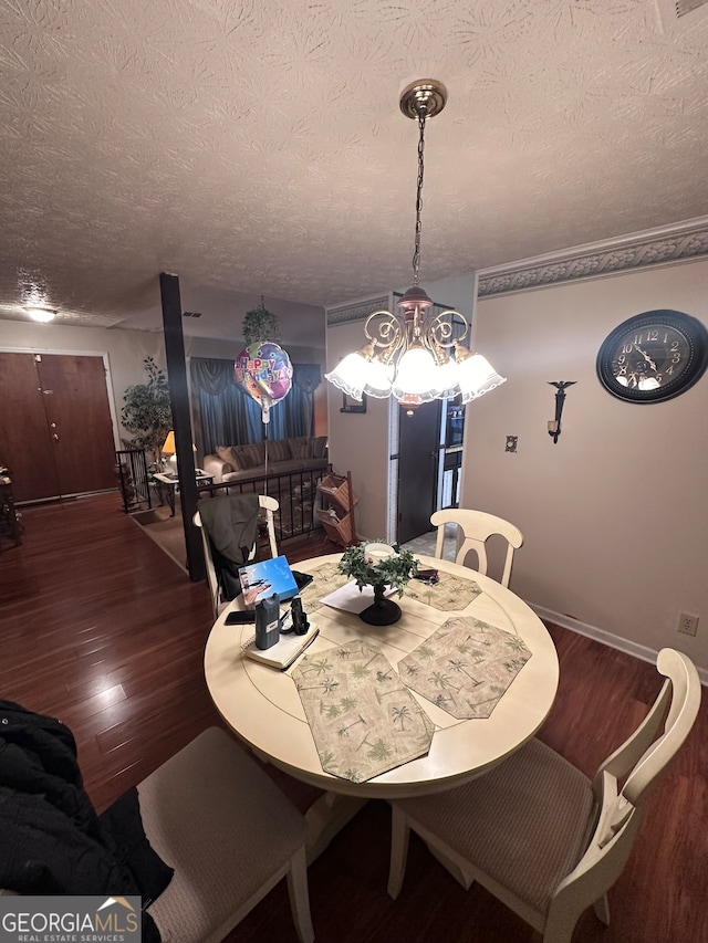 dining space with a notable chandelier, a textured ceiling, and dark wood-type flooring