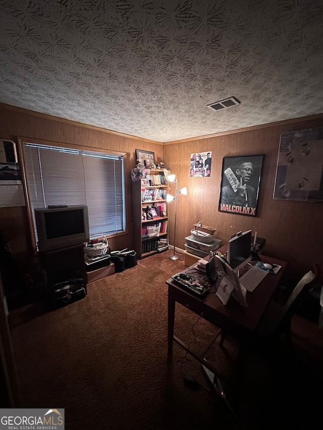 interior space with a textured ceiling, wood walls, and dark carpet