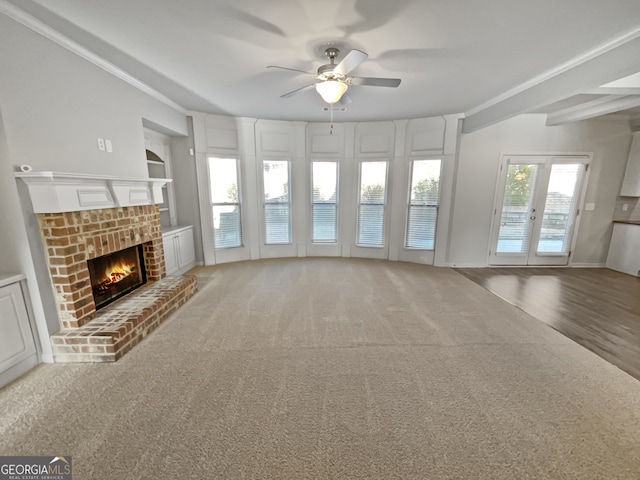 unfurnished living room with ceiling fan, a brick fireplace, light carpet, and plenty of natural light