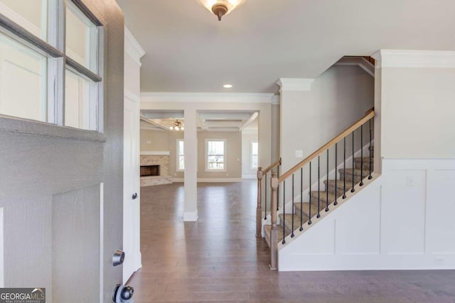 foyer entrance featuring a fireplace, dark hardwood / wood-style floors, and ornamental molding