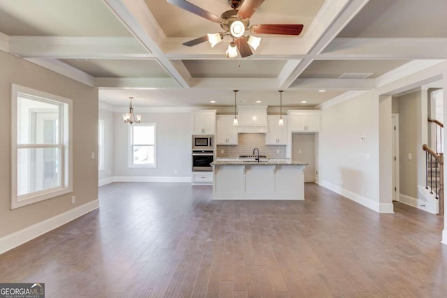 unfurnished living room featuring coffered ceiling, dark hardwood / wood-style floors, and beamed ceiling