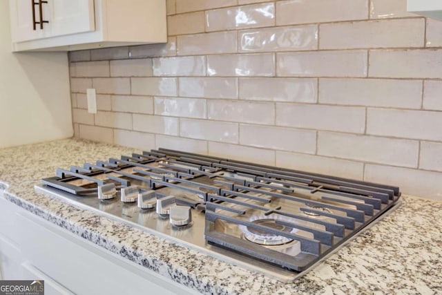 details with backsplash and stainless steel gas cooktop