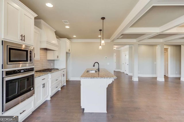 kitchen featuring stainless steel appliances, custom exhaust hood, a center island with sink, backsplash, and dark hardwood / wood-style flooring