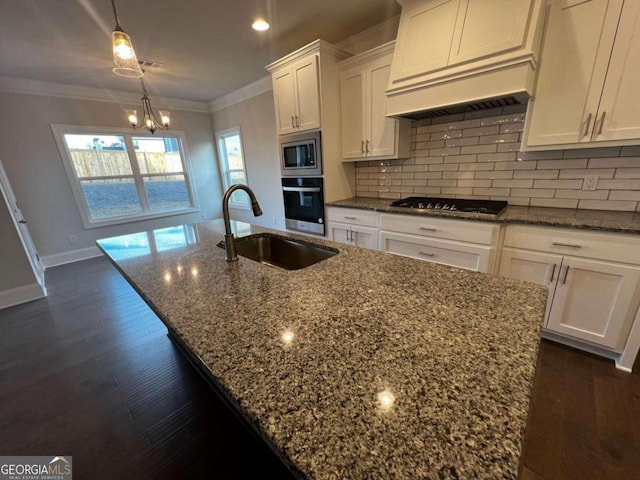 kitchen with stainless steel appliances, dark stone counters, a chandelier, and custom exhaust hood