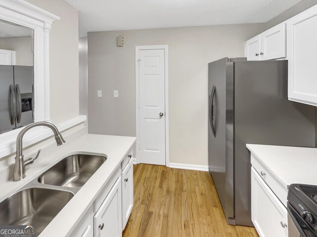 kitchen featuring sink, stainless steel refrigerator with ice dispenser, light wood-type flooring, white cabinetry, and stainless steel refrigerator