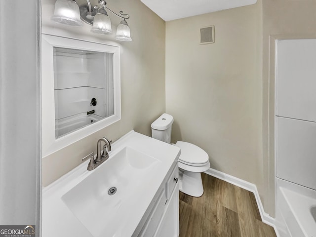 full bathroom with bathing tub / shower combination, vanity, hardwood / wood-style flooring, and toilet