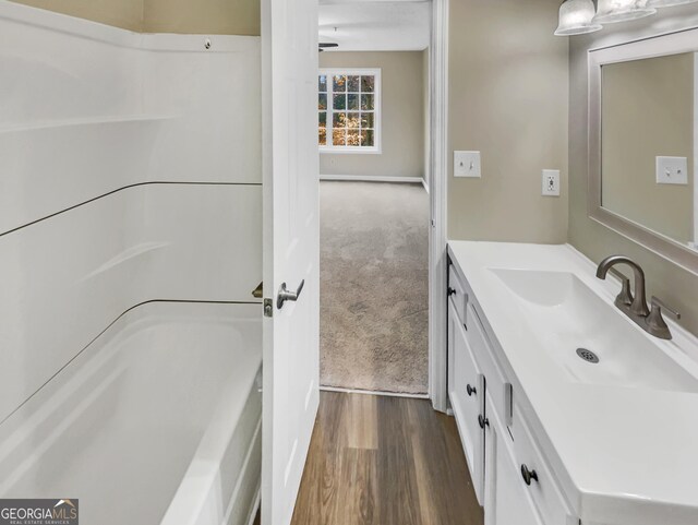 bathroom with vanity, a shower, and wood-type flooring