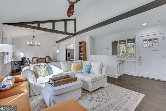 living room with an inviting chandelier, lofted ceiling with beams, and dark wood-type flooring