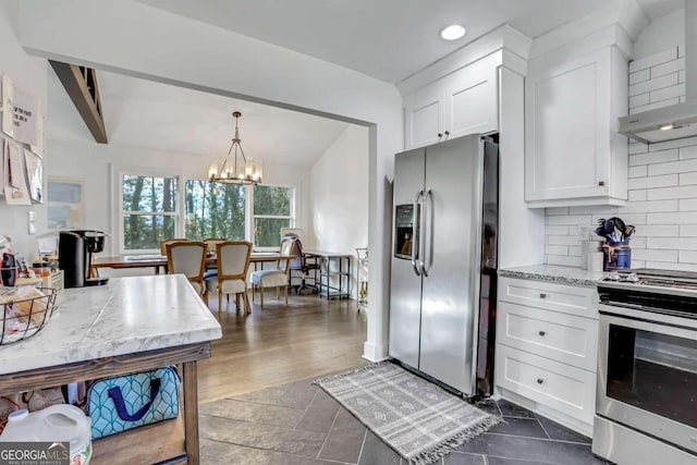 kitchen featuring appliances with stainless steel finishes, backsplash, white cabinetry, and decorative light fixtures