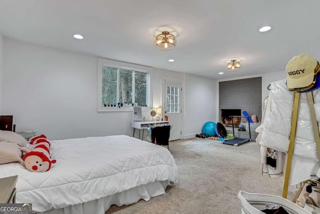 carpeted bedroom featuring a brick fireplace