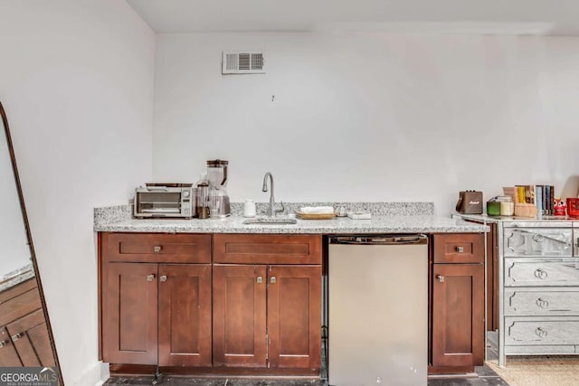 kitchen with refrigerator, sink, and light stone countertops