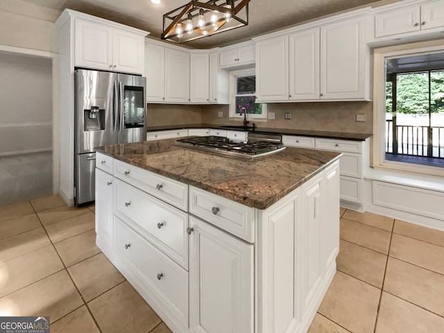 kitchen featuring sink, appliances with stainless steel finishes, light tile patterned floors, hanging light fixtures, and a kitchen island