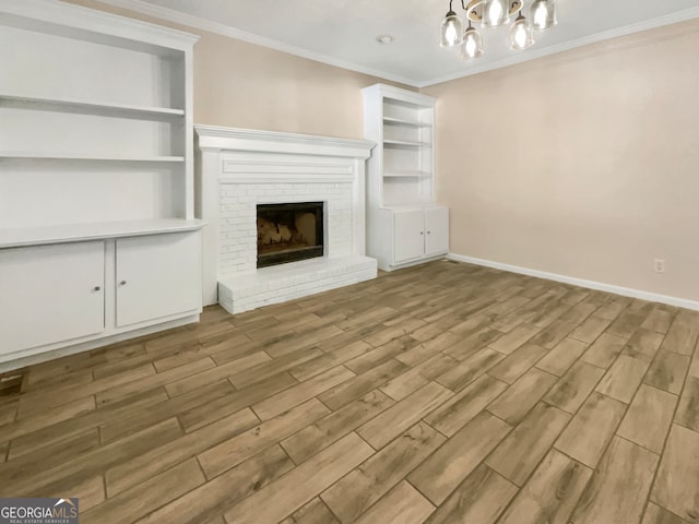 unfurnished living room featuring ornamental molding, light wood-type flooring, a fireplace, and built in shelves