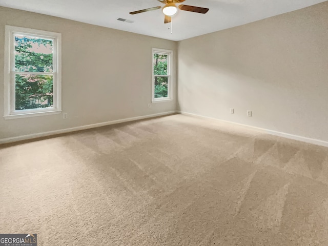 carpeted spare room featuring ceiling fan