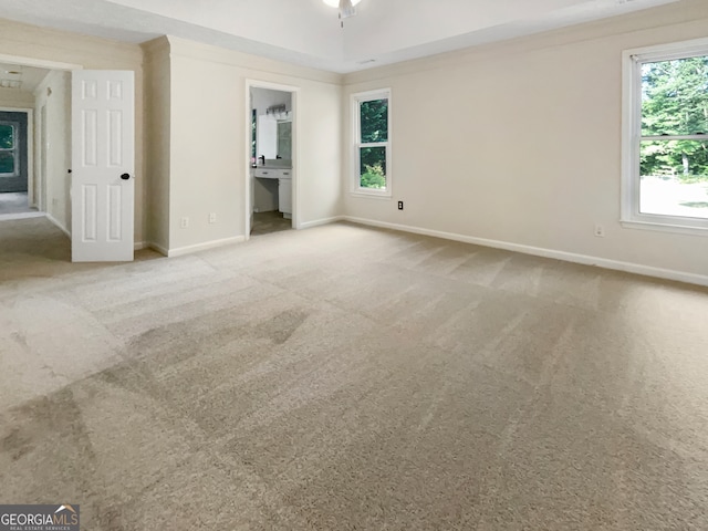 carpeted empty room with a wealth of natural light and ceiling fan