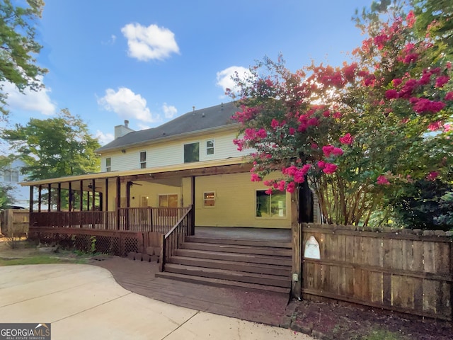 rear view of property featuring ceiling fan and a patio