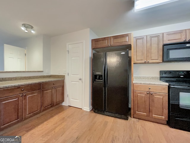 kitchen featuring light hardwood / wood-style flooring and black appliances