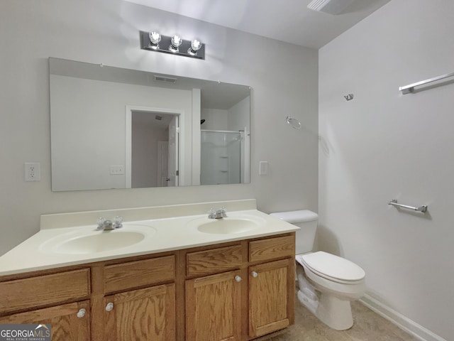 bathroom featuring vanity, toilet, and a shower with shower door