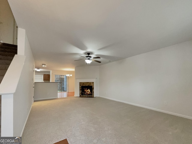 unfurnished living room with ceiling fan, light carpet, and a high end fireplace