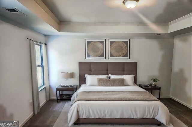 bedroom featuring a tray ceiling and dark hardwood / wood-style flooring