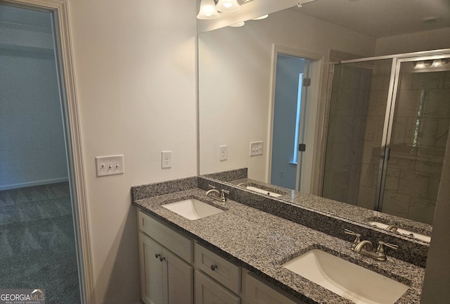 bathroom featuring walk in shower, dual sinks, and large vanity