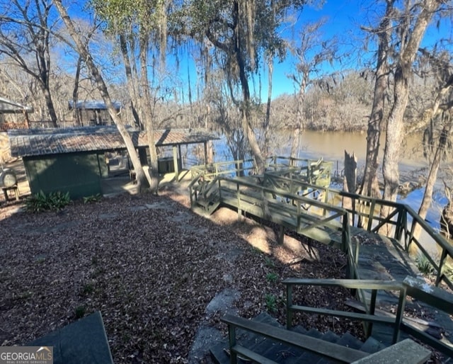 view of yard with a water view and a boat dock