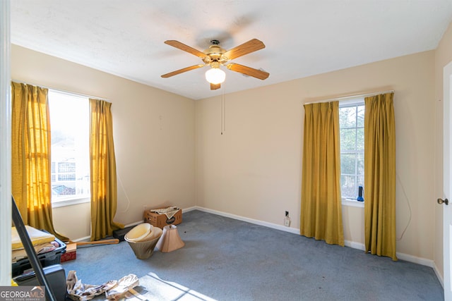 carpeted spare room with ceiling fan