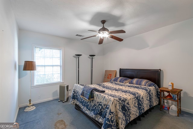 carpeted bedroom with ceiling fan and radiator