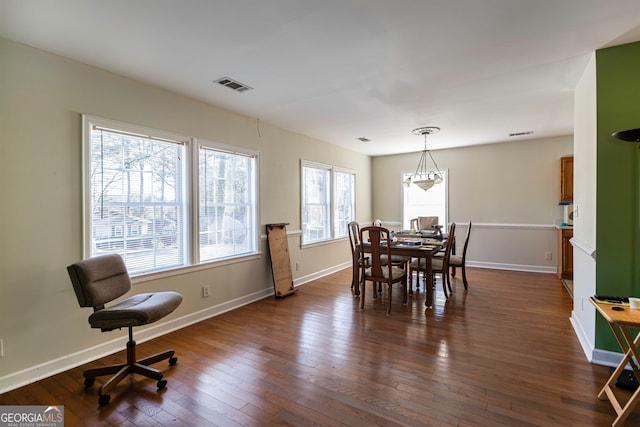 dining space featuring dark hardwood / wood-style flooring and a chandelier