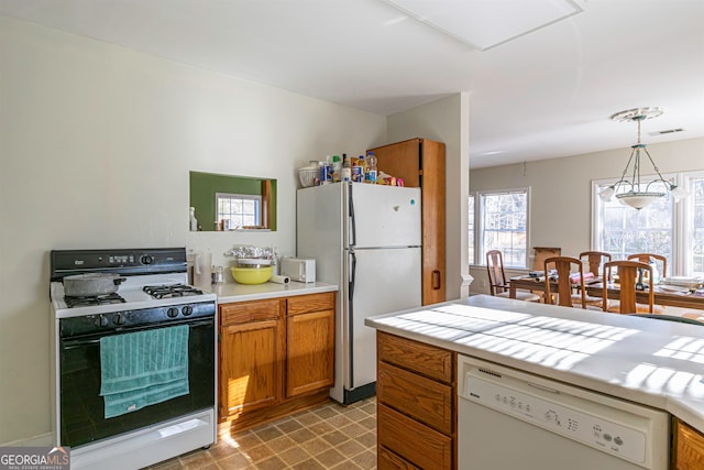 kitchen with white appliances, pendant lighting, and light tile floors