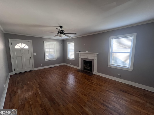 unfurnished living room with ceiling fan, dark hardwood / wood-style floors, crown molding, and a fireplace