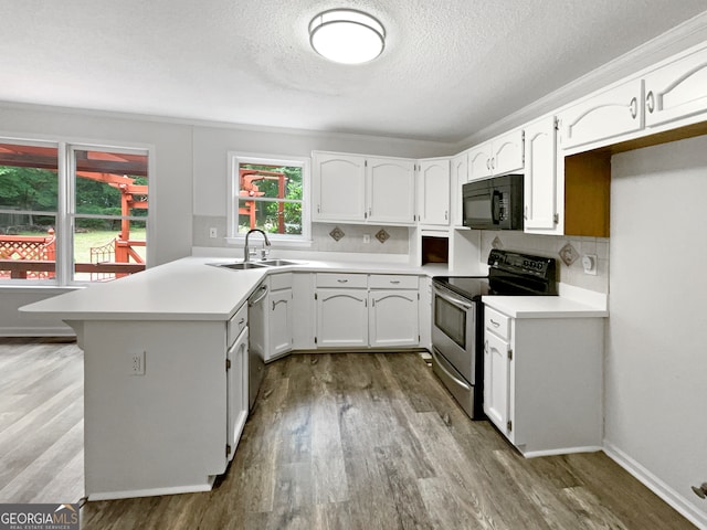 kitchen featuring light wood-type flooring, tasteful backsplash, sink, white cabinetry, and stainless steel appliances