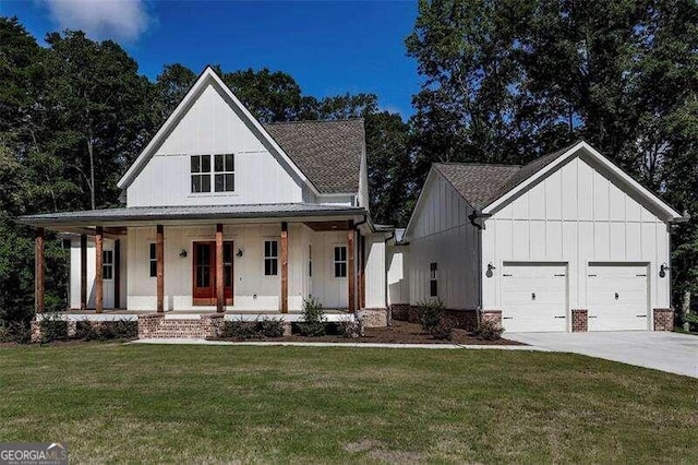 modern farmhouse with covered porch, a front yard, and a garage