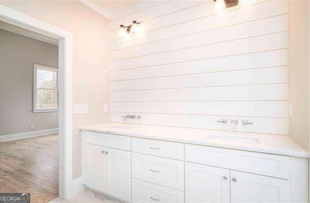 bathroom with double vanity and wood-type flooring