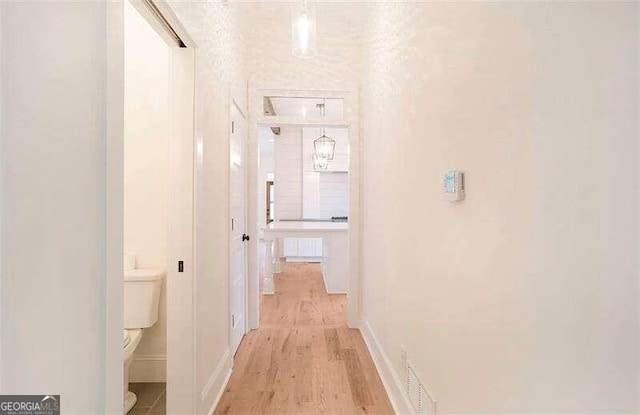 corridor with light hardwood / wood-style floors