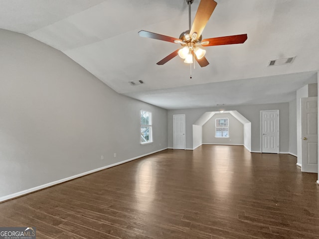 unfurnished living room with ceiling fan, dark wood-type flooring, and vaulted ceiling