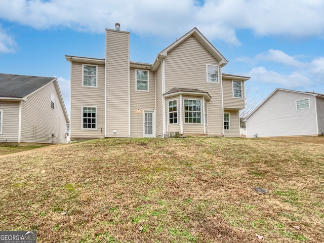 rear view of property featuring a lawn