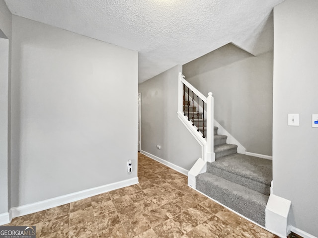 stairs with a textured ceiling