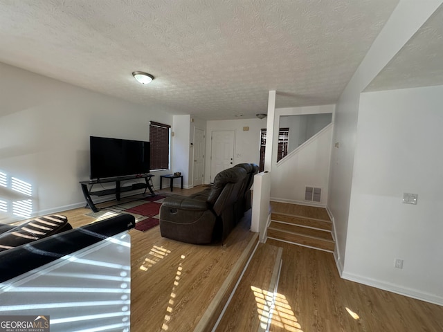 living room with a textured ceiling and dark wood-type flooring