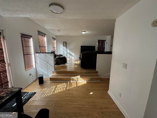 hallway featuring a textured ceiling and light hardwood / wood-style flooring