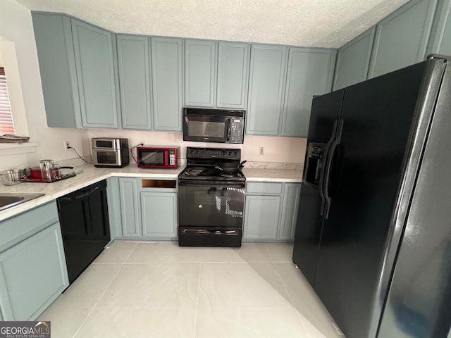 kitchen featuring a textured ceiling, light tile floors, and black appliances