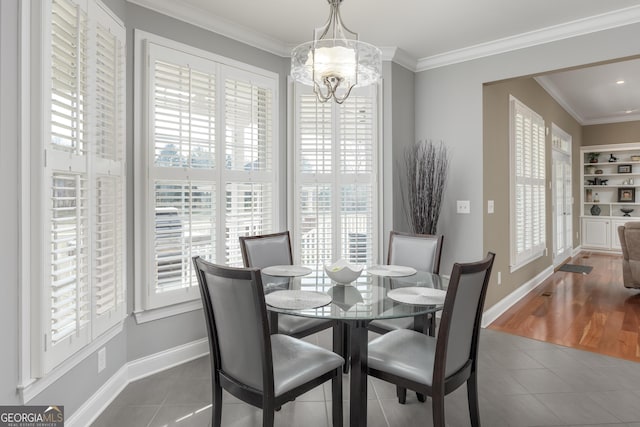 dining space with an inviting chandelier, ornamental molding, a wealth of natural light, and wood-type flooring