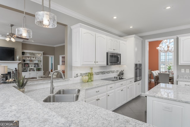 kitchen featuring pendant lighting, stainless steel appliances, light tile floors, ceiling fan with notable chandelier, and white cabinets