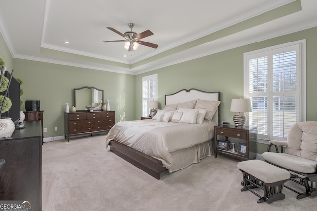 carpeted bedroom with a raised ceiling, ceiling fan, and crown molding