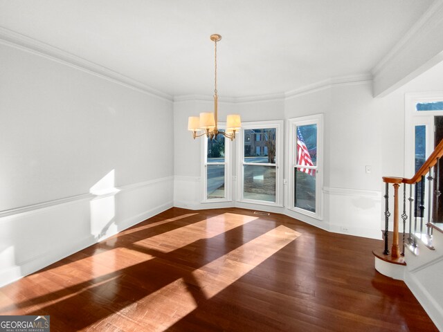 unfurnished dining area with crown molding, an inviting chandelier, and dark hardwood / wood-style floors