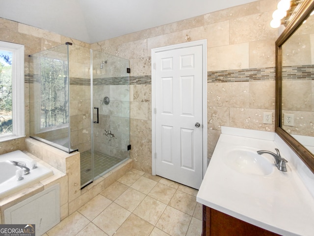 bathroom with independent shower and bath, vanity, and tile walls