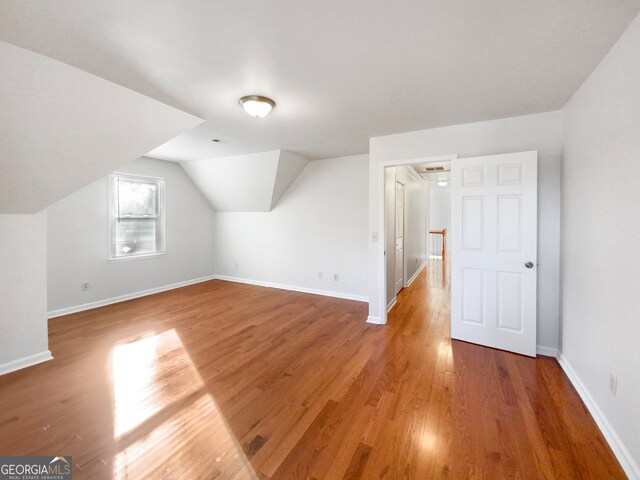 additional living space featuring hardwood / wood-style flooring and vaulted ceiling