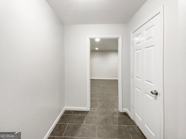 hallway with dark tile floors