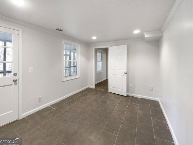 tiled spare room featuring crown molding