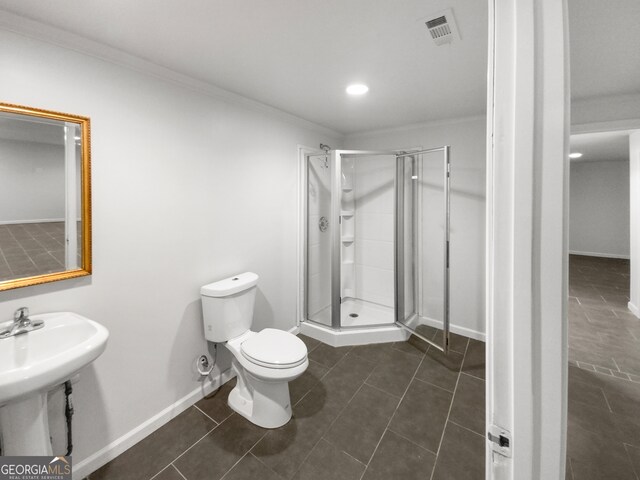 bathroom featuring a shower with door, ornamental molding, toilet, and tile floors